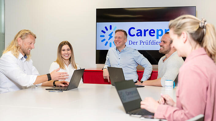 Careproof Mitarbeiter zusammen an einem Tisch im Gespräch
